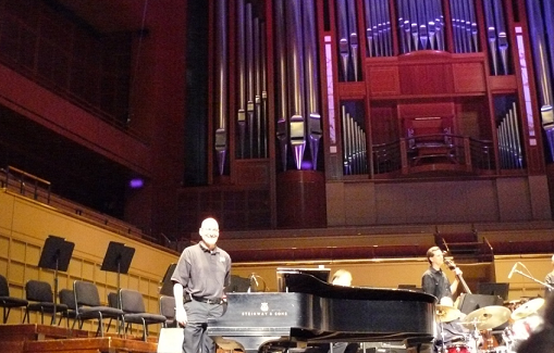 Dallas musical performer Mark Ripley bows to the audience image of organ pipes piano